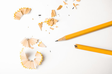 Broken pencil and shavings on white background, top view