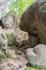 Obraz premium beautiful girl tourist with a backpack on a cliff, mountains, rocks Dovbush, Ukraine