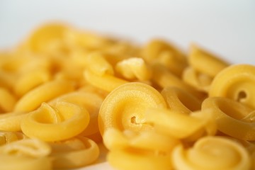 Top view on Italian messicani pasta shapes on white background