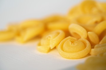 Top view on Italian messicani pasta shapes on white background
