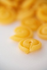 Top view on Italian messicani pasta shapes on white background