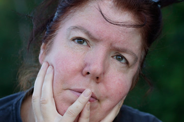 Portrait einer nachdenklichen Frau mit dunklen Haaren und Blick nach oben