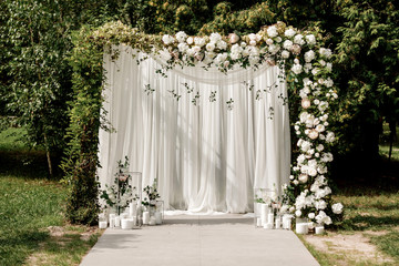 Wedding ceremony arch decor with white roses and green outside