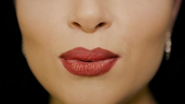The girl speaks the words on the camera. The lips with red lipstick