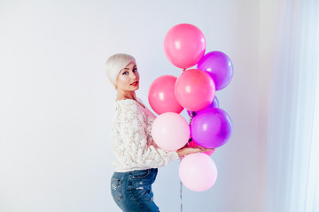beautiful blonde with balloons and gifts on the holiday