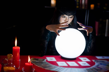 Fortune Teller young Asian woman Gypsy glowing crystal ball, tarot cards, magic, and composition...