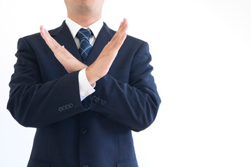 両腕でバツをしているスーツの男性