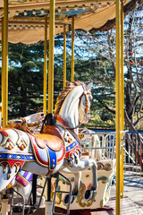 Naklejka na ściany i meble Carousel colorful horses in amusement park.