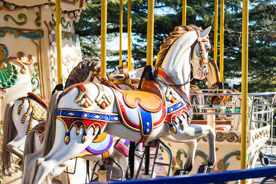 Carousel colorful horses in amusement park.
