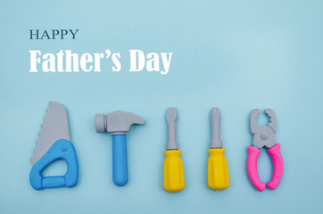 Conceptual flat lay for holiday Father's Day. Mini tools workers on a blue background.