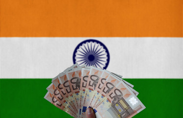 India flag with Euro banknotes in the hand