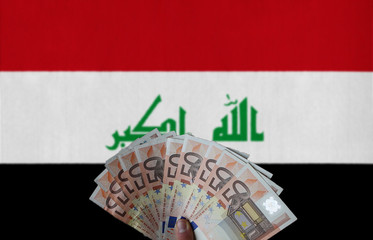 Iraq flag with Euro banknotes in the hand