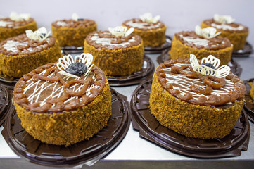 A lot of chocolate sponge cakes with condensed milk and prunes in the confectionery industry, making. Food industry, torte
