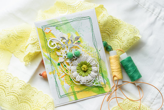 Yellow and green scrapbooking greeting card with flowers, butterfly, bird. Spring concept. Greeting cards for wedding or other festive decorations . Tools for scrapbooking.