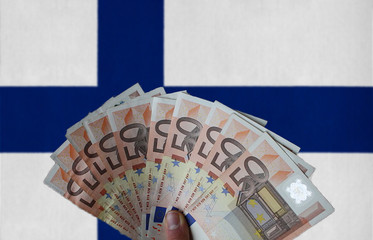 Finland flag with Euro banknotes in the hand