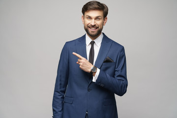 Portrait of a young businessman pointing on a copyspace with his finger