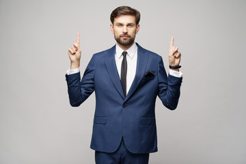 Portrait of a young businessman pointing on a copyspace with his finger