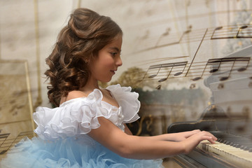 girl young princess in white with a blue dress and a barrette in black hair curls at the piano