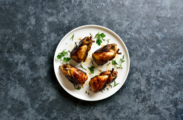 Roasted quails on white plate