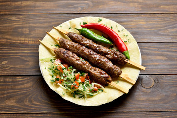 Turkish Adana Kebab with fresh vegetables on flatbread