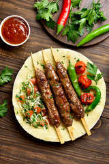 Turkish Adana Kebab with fresh vegetables on flatbread