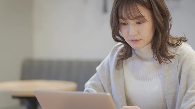 カフェでノートパソコンを操作している女性