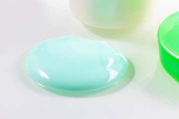 jar with cream and a green lid. the bank is open and there is a cruise nearby. close-up. on white background.