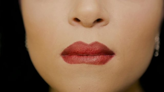 Woman licks his lips with red lipstick
