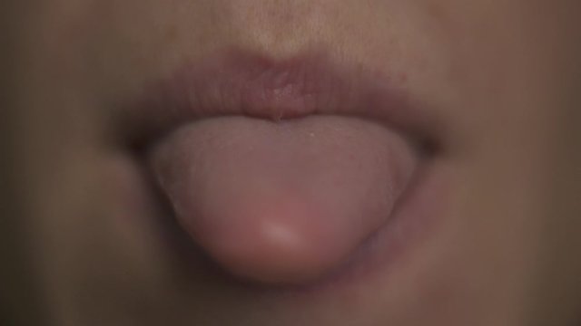 Macro Close up. Young woman open mouth and shows a pink tongue, smile, teeth. Face part. No make up natural beauty.