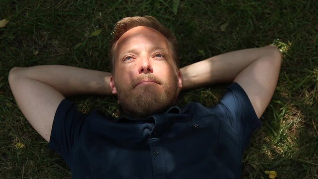 Hombre tumbado en la hierva de forma relajada