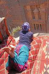 Jordan may 26 , 2019 woman traveler sitting on carpet viewpoint in Petra ancient city looking at...