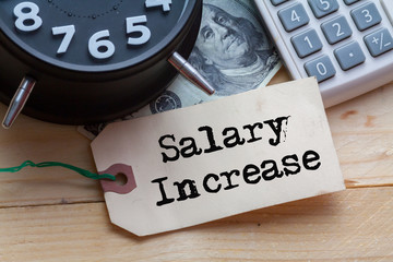 Salary Increase Word on tag with clock,dollar note and calculator,Finance Concept