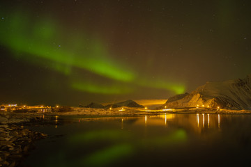 Fisherman village with northern light in the background. Travel for explore the Aurora. Lofoten, Norway.