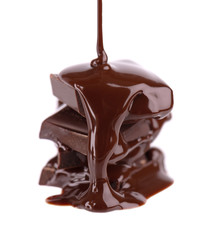 Chocolate pieces stack and chocolate syrup isolated on white background. Close up.