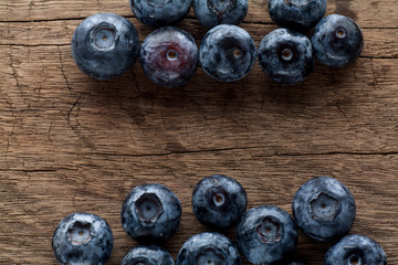 Freshly picked blueberries in wooden background. Juicy and fresh blueberries with green leaves on rustic table.Concept for healthy eating and nutrition