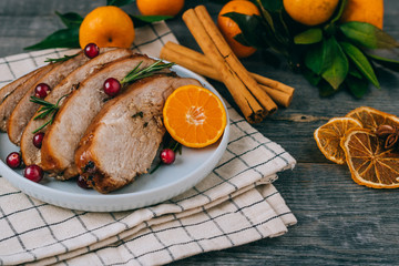 Roasted turkey or chicken with orange slices in plate for Christmas dinner served and festive decoration on dark rustic background