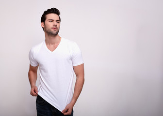 Epitome of masculinity. Handsome man shows off his perfect body looking away, isolated over white background.