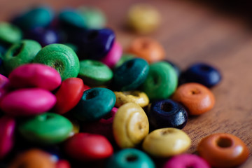 colorful beads on a wooden plate