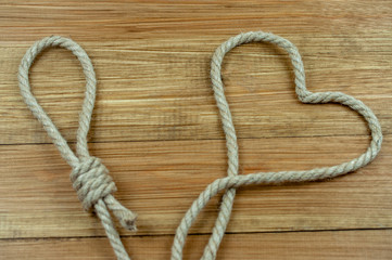 loop and heart of rope on wooden background