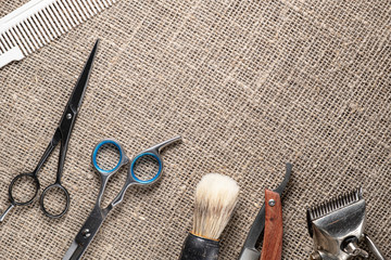 vintage barber tools dangerous razor hairdressing scissors old manual clipper comb shaving brush. on sackcloth background.