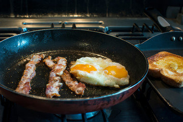 Delicious breakfast of eggs, bacon and bread with butter
