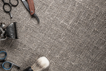 vintage barber tools dangerous razor hairdressing scissors old manual clipper comb shaving brush. on sackcloth background.