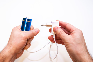 Batteries and charger in the hands of a man on a white background. isolated. Energy storage.