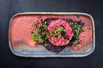 Gourmet fish tartar raw from tuna fillet with hashed avocado, wasabi and Japanese spice as top view...