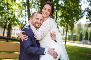 loving couple of stylish newlyweds walks and kisses in the old city in summer sunny day