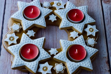 Christmas advent wreath of star-shaped gingerbread with red tea candles