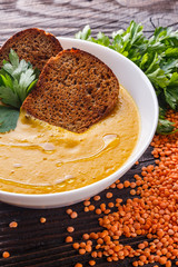 lentil cream soup on rustic wooden background