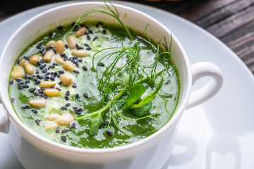 broccoli spinach cream soup on rustic wooden background