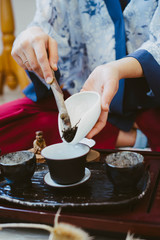 The tea master pours dry leaves of Chinese tea into a clay pot. Tea ceremony. The process of brewing Chinese tea.