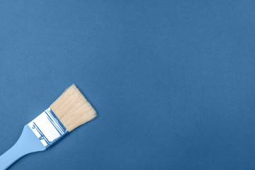 Brush with natural bristles on a blue background. The main color concept